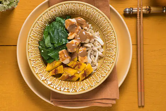 Arroz de cogumelo servido com frango, couve, banana e molho de amendoim