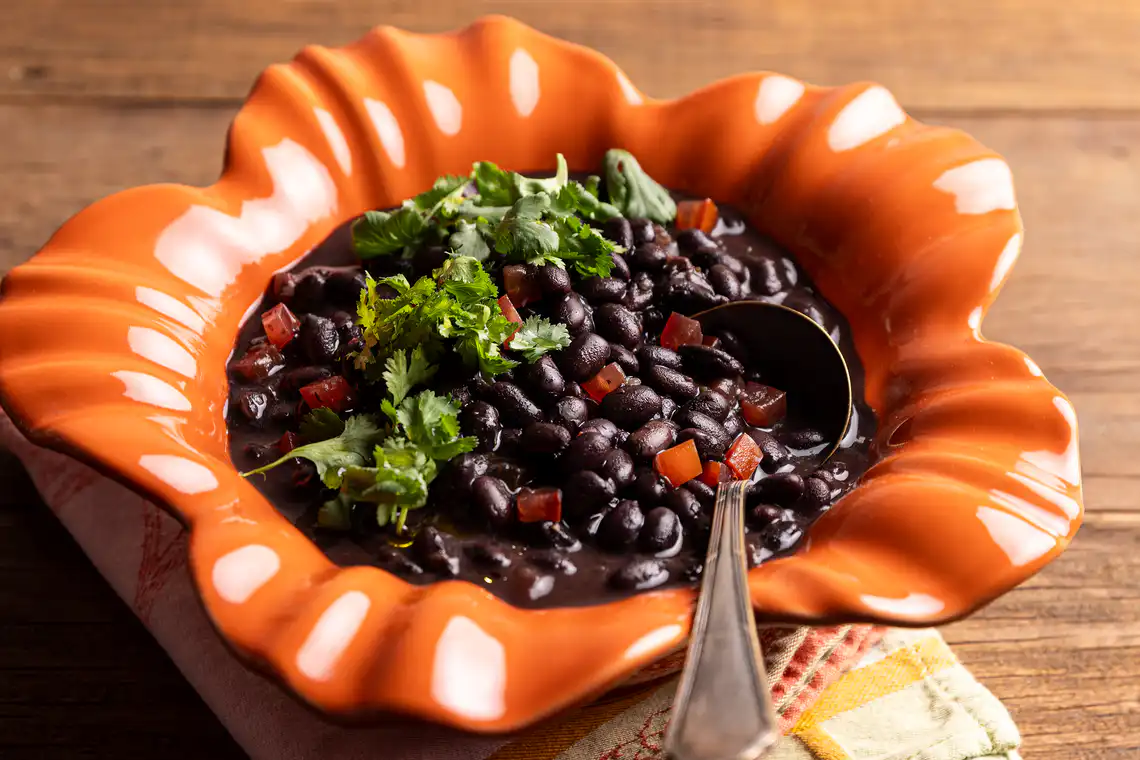 Feijão-preto com tomate e folhas de coentro